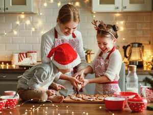 Photo d'une famille avec enfants qui cuisinent ensemble pour les fêtes de Noël